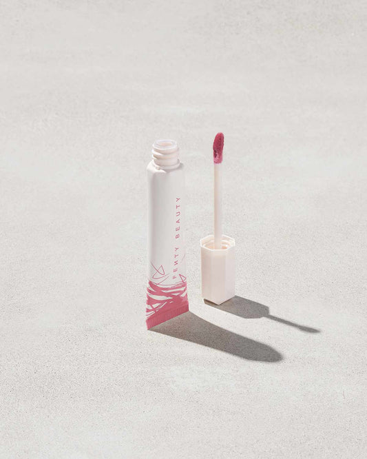 Open tube of Pro Kiss'r Luscious Lip Balm in shade Pinch Me on grey background.
