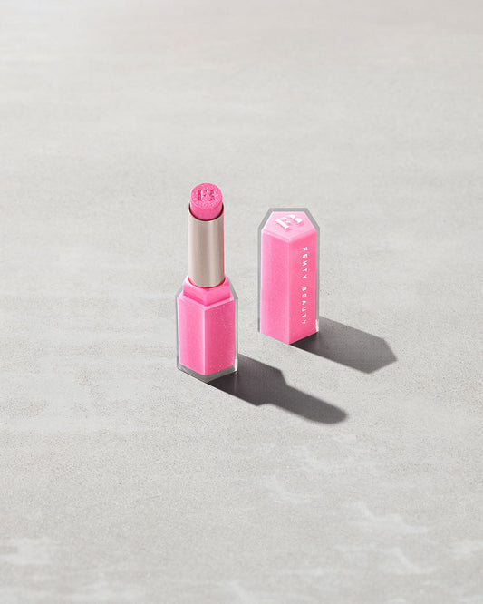 Open product shot of Gloss Bomb Stix Shimmer in shade Flamingo Fling on a concrete background.
