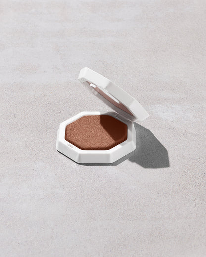 Open product shot of Demi'glow Light-Diffusing Highlighter in shade Java Jitters on a concrete backdrop.